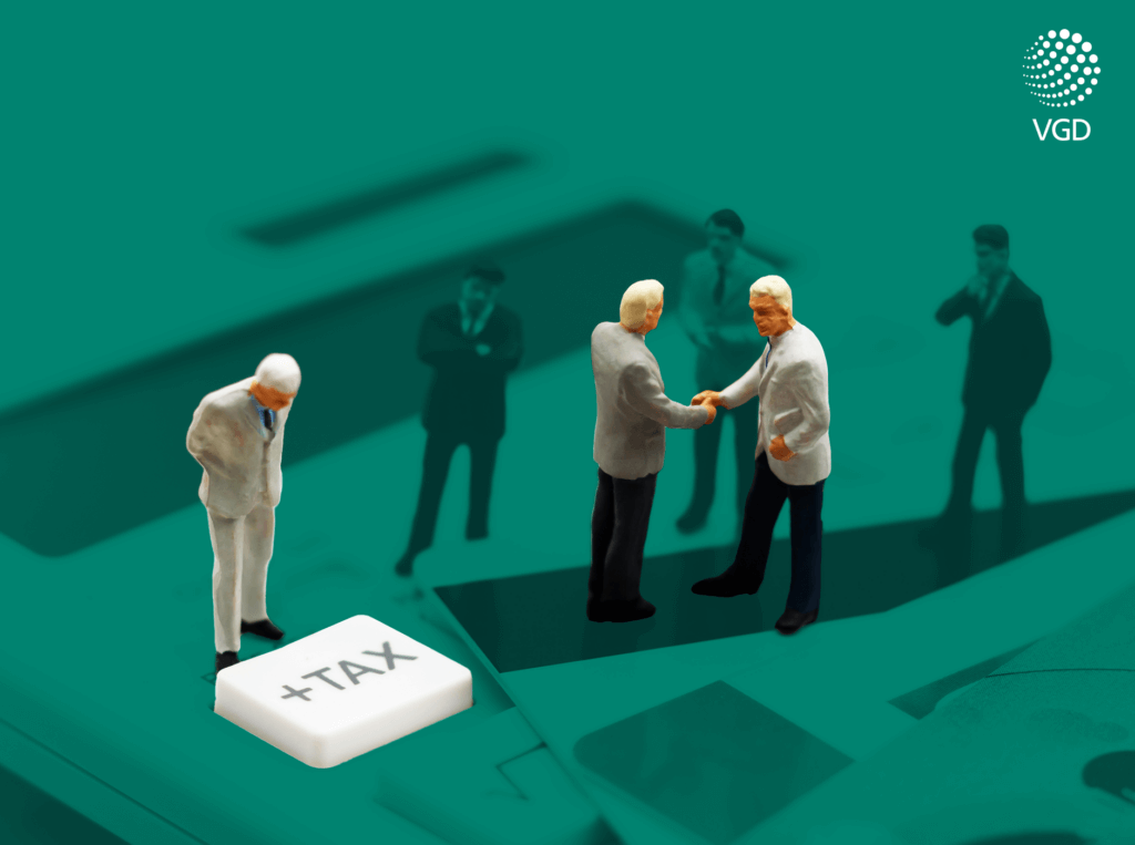 miniature men standing on a calculator and analyzing tax