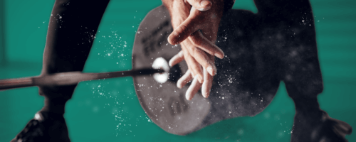 a man rubbing talk in his palms to get ready to lift a weight bar