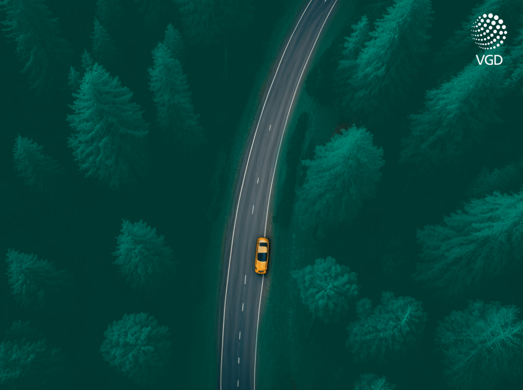 yellow car on a road in the woods
