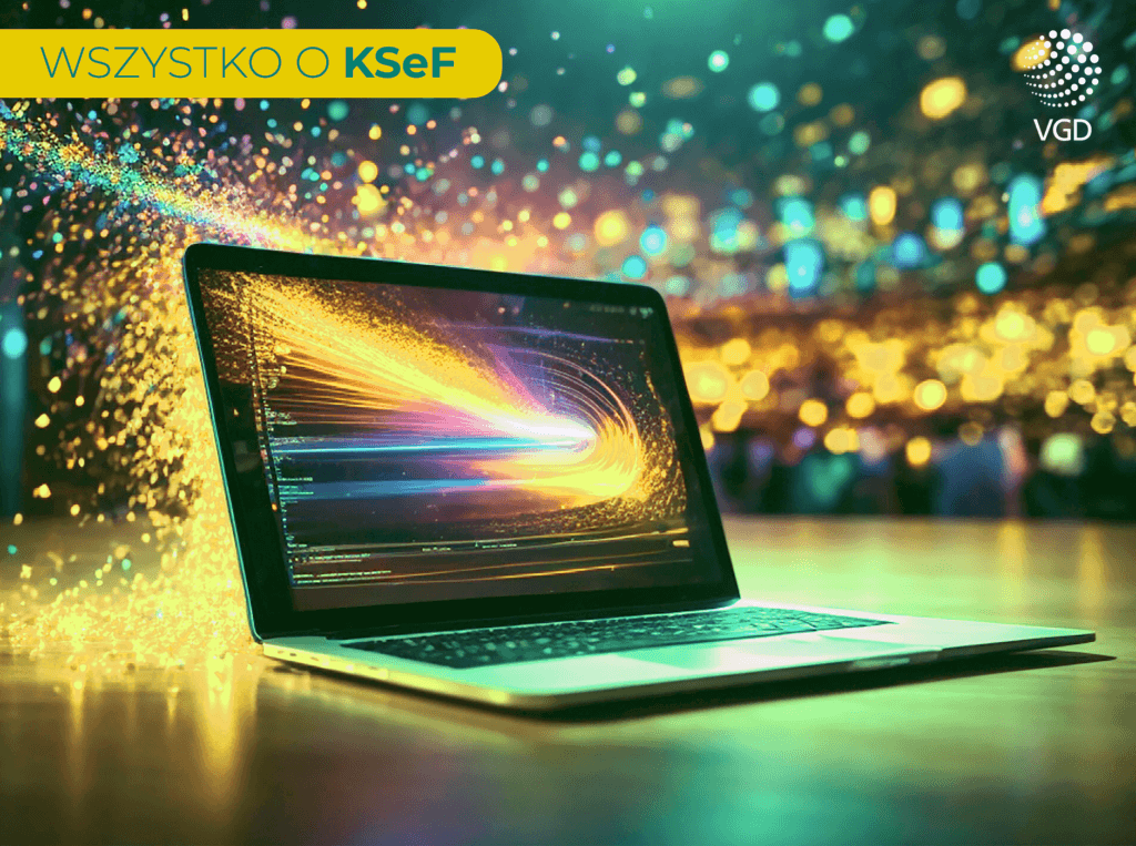 na biurku jest postawiony laptop. Na ekranie laptopa odbywa się proces, któremu towarzyszą iskry i błyskotki