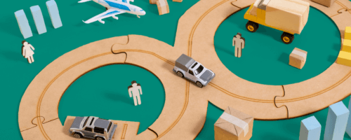 Obrazek przedstawia schematyczną scenę transportu i logistyki na żółtym tle, z wykorzystaniem drewnianych elementów i figurek.
