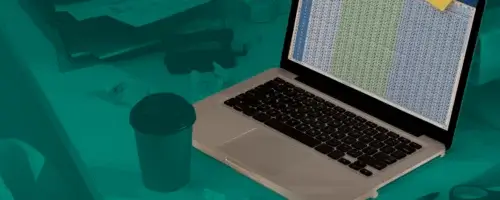 Grafika przedstawiająca laptop z otwartym arkuszem kalkulacyjnym i kolorowymi karteczkami samoprzylepnymi z oznaczeniami dokumentów. Na biurku znajdują się kalkulator, kubek z kawą i dokumenty, a całość utrzymana jest w zielono-turkusowej kolorystyce nawiązującej do cyfrowej księgowości i e-fakturowania.